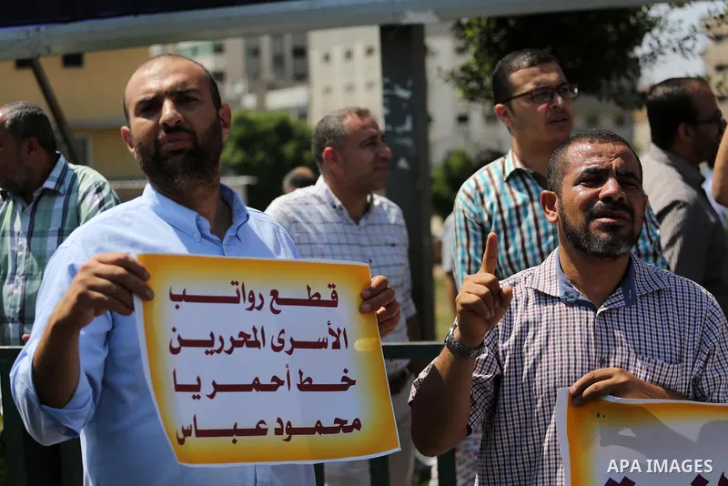 Palestinian released prisoners from Israeli jails hold placards during a protest demanding their salaries in Gaza city on July 9, 2017. Photo by Mohammed Asad