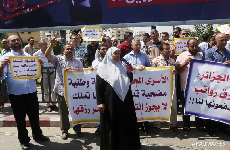Palestinian released prisoners from Israeli jails hold placards during a protest demanding their salaries in Gaza city on July 9, 2017. Photo by Mohammed Asad