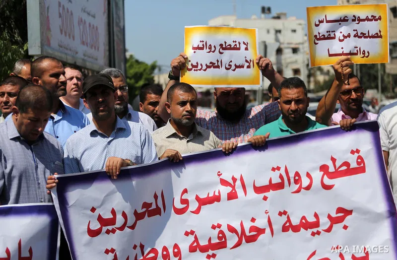 Palestinian released prisoners from Israeli jails hold placards during a protest demanding their salaries in Gaza city on July 9, 2017. Photo by Mohammed Asad