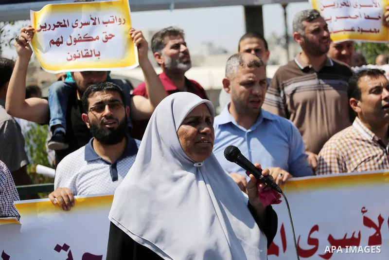 Palestinian released prisoners from Israeli jails hold placards during a protest demanding their salaries in Gaza city on July 9, 2017. Photo by Mohammed Asad