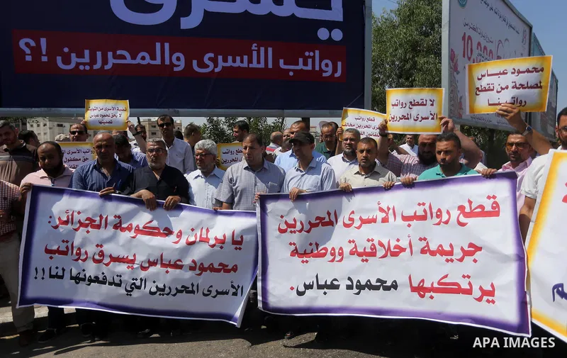 Palestinian released prisoners from Israeli jails hold placards during a protest demanding their salaries in Gaza city on July 9, 2017. Photo by Mohammed Asad