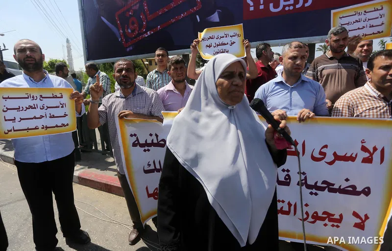 Palestinian released prisoners from Israeli jails hold placards during a protest demanding their salaries in Gaza city on July 9, 2017. Photo by Mohammed Asad