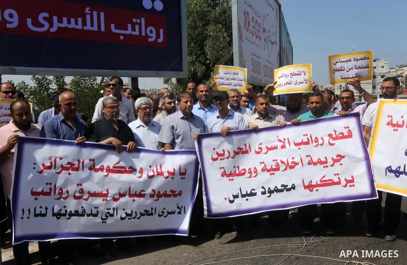 Palestinian released prisoners from Israeli jails hold placards during a protest demanding their salaries in Gaza city on July 9, 2017. Photo by Mohammed Asad