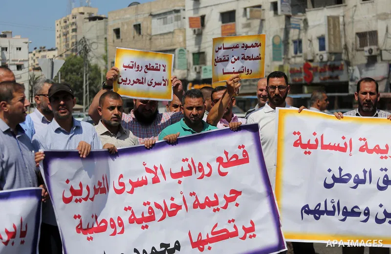 Palestinian released prisoners from Israeli jails hold placards during a protest demanding their salaries in Gaza city on July 9, 2017. Photo by Mohammed Asad