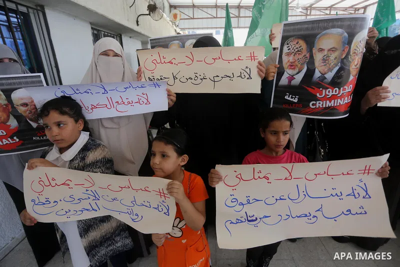 Palestinian women hold placards during a protest against Israeli blockade at Legislative council in Gaza city on July 9, 2017. Photo by Mohammed Asad