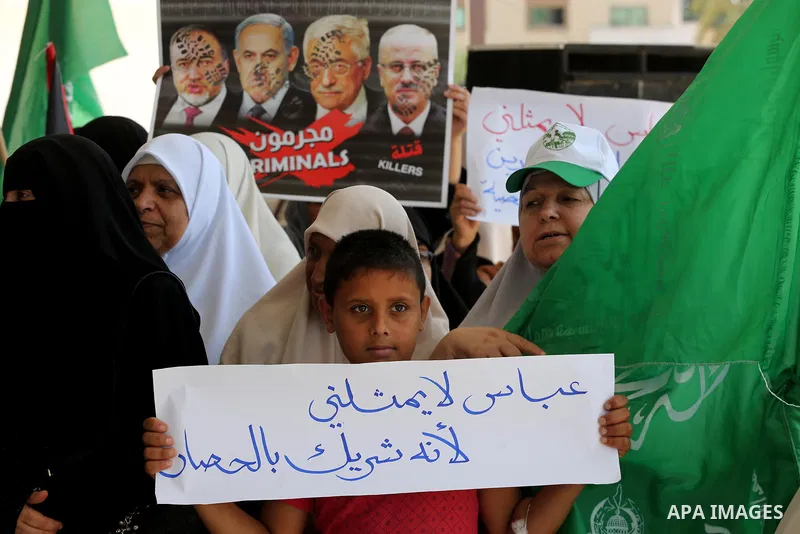 Palestinian women hold placards during a protest against Israeli blockade at Legislative council in Gaza city on July 9, 2017. Photo by Mohammed Asad