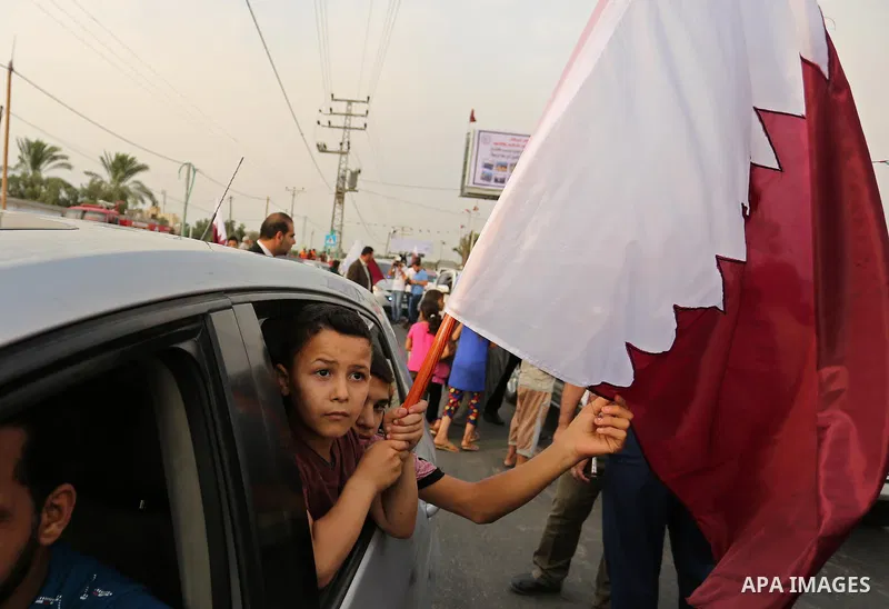 A Palestinian boy waves the Qatar flag during the opening ceremony of rebuild Salah Al-Deen street project -Phase IV- funded by Qatar in al-Nusairat in the center of Gaza strip, on July 11, 2017. Photo by Ashraf Amra