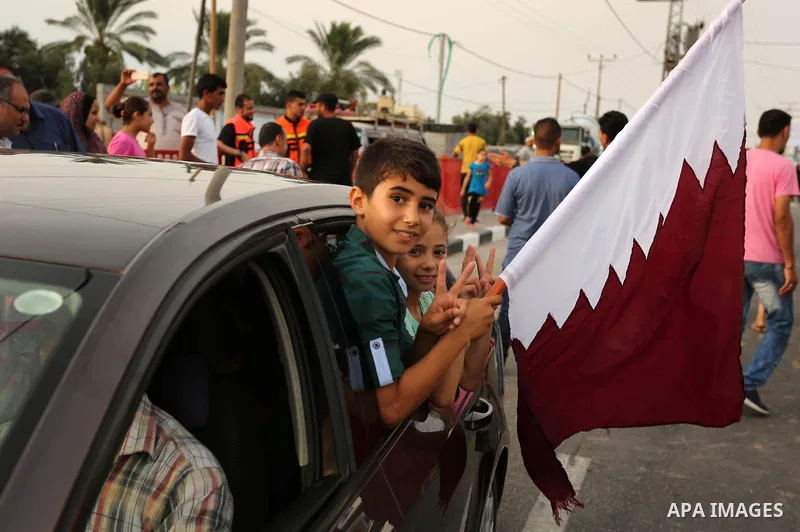 A Palestinian boy waves the Qatar flag during the opening ceremony of rebuild Salah Al-Deen street project -Phase IV- funded by Qatar in al-Nusairat in the center of Gaza strip, on July 11, 2017. Photo by Ashraf Amra