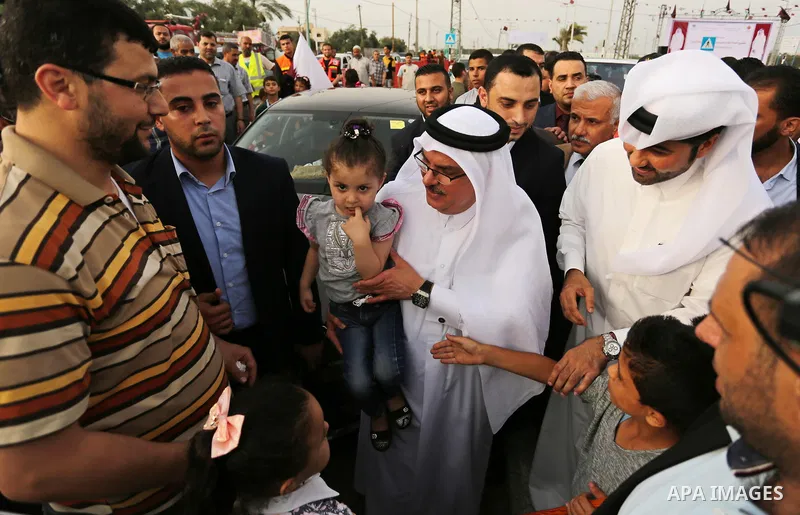 Qatar's Ambassador to the Palestinian Authority, Mohammed Al Emadi holds a Palestinian girl during the opening ceremony of rebuild Salah Al-Deen street project -Phase IV- funded by Qatar in al-Nusairat in the center of G...