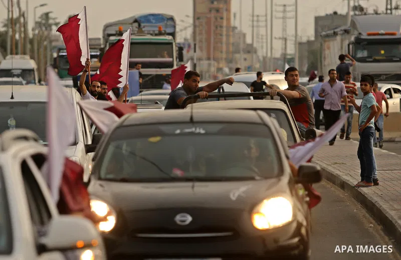 Palestinians wave the Qatar flag during the opening ceremony of rebuild Salah Al-Deen street project -Phase IV- funded by Qatar in al-Nusairat in the center of Gaza strip, on July 11, 2017. Photo by Ashraf Amra