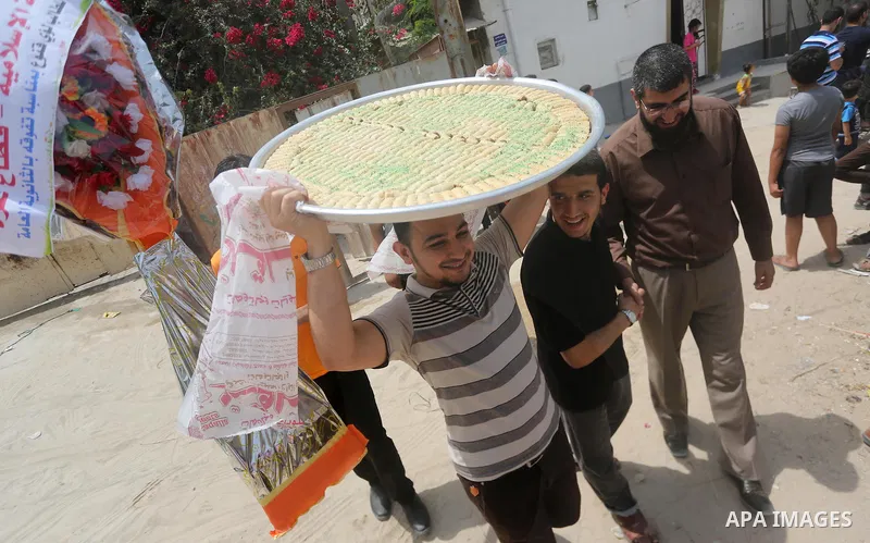 Relatives of a Palestinian high school student, Loa'y Qnoua 99.7, celebrate after heard the results of his final exams known as ''Tawjihi'', in Gaza city on July 12, 2017. Photo by Mohammed Asad
