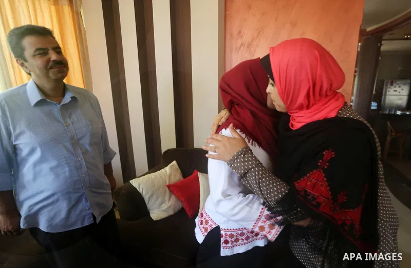 A Palestinian high school student, Malak Matar 99.3, celebrates with her family after heard the results of her final exams known as ''Tawjihi'', in Gaza city on July 12, 2017. Photo by Mohammed Asad
