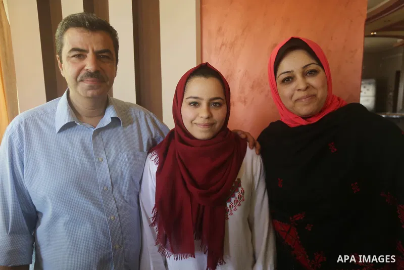 A Palestinian high school student, Malak Matar 99.3, celebrates with her family after heard the results of her final exams known as ''Tawjihi'', in Gaza city on July 12, 2017. Photo by Mohammed Asad