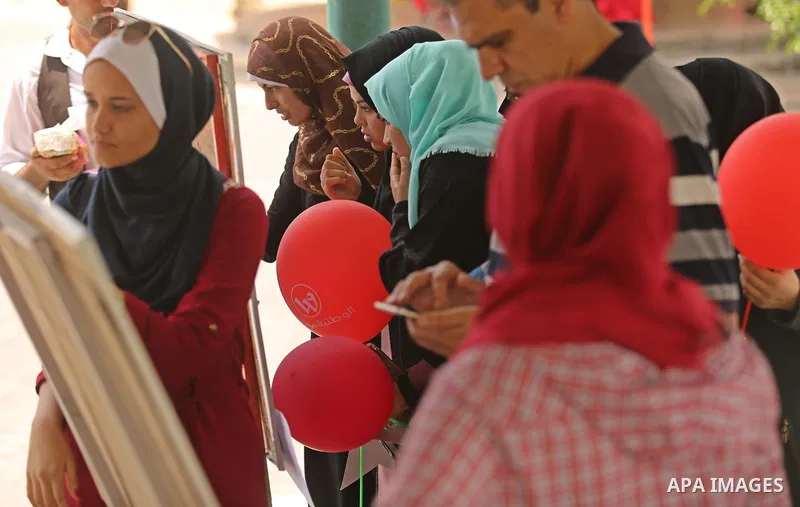 Palestinian high school students look for their results of final high school exams, known as "Tawjihi", in Gaza city on July 12, 2017. Photo by Ashraf Amra