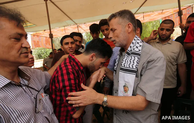 A Palestinian high school student, Loa'y Qnoua 99.7, celebrates with his family after heard the results of his final exams known as ''Tawjihi'', in Gaza city on July 12, 2017. Photo by Ashraf Amra