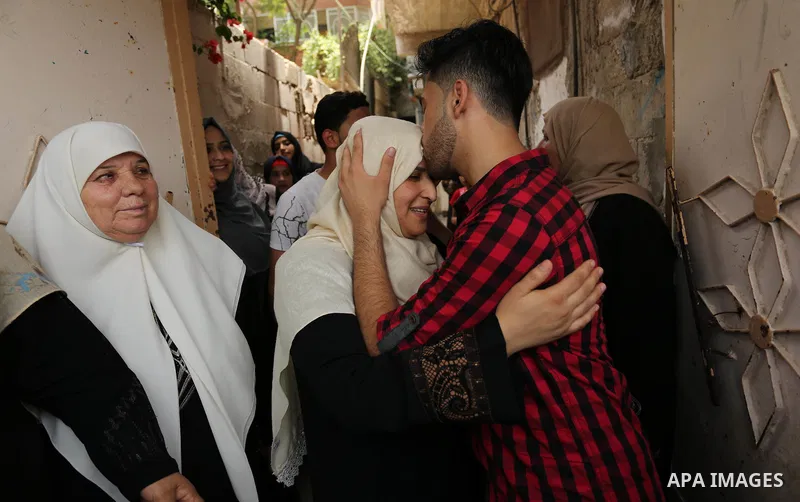 A Palestinian high school student, Loa'y Qnoua 99.7, celebrates with his family after heard the results of his final exams known as ''Tawjihi'', in Gaza city on July 12, 2017. Photo by Ashraf Amra
