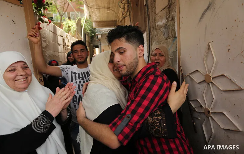 A Palestinian high school student, Loa'y Qnoua 99.7, celebrates with his family after heard the results of his final exams known as ''Tawjihi'', in Gaza city on July 12, 2017. Photo by Ashraf Amra