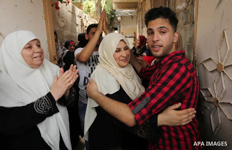 A Palestinian high school student, Loa'y Qnoua 99.7, celebrates with his family after heard the results of his final exams known as ''Tawjihi'', in Gaza city on July 12, 2017. Photo by Ashraf Amra
