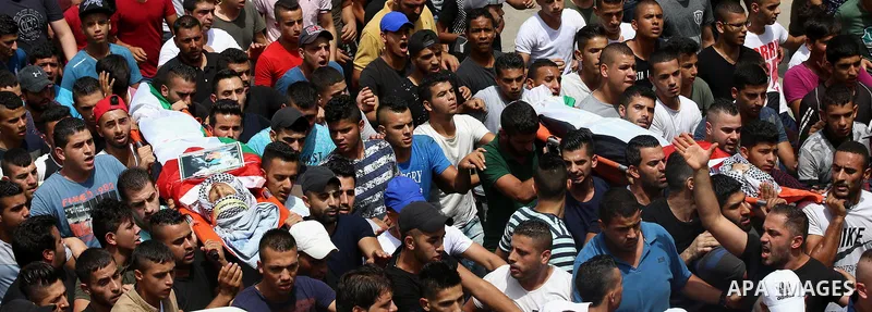 Palestinian mourners carry the bodies of 21-year-old Saad Salah during a funeral for Saad and 17-year-old Aws Salame, who were shot dead during clashes with the Israeli security forces in the West Bank city of Jenin, on...