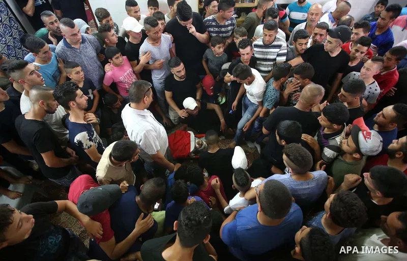 Relatives of 21-year-old Saad Salah mourn over his body during the funeral of Saad and 17-year-old Aws Salame, who were shot dead during clashes with the Israeli security forces in the West Bank city of Jenin, on July 12...