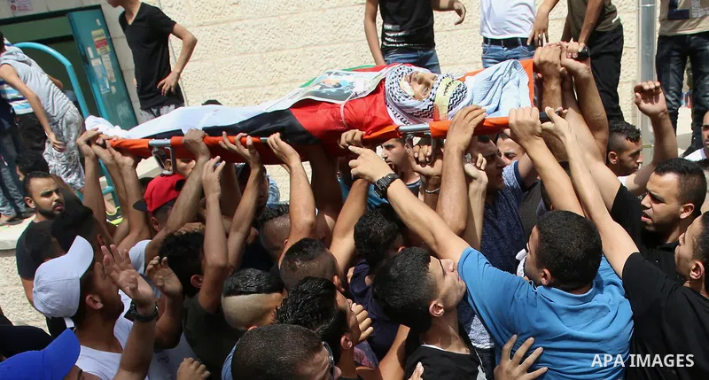 Palestinian mourners carry the body of 21-year-old Saad Salah during a funeral for Saad and 17-year-old Aws Salame, who were shot dead during clashes with the Israeli security forces in the West Bank city of Jenin, on Ju...