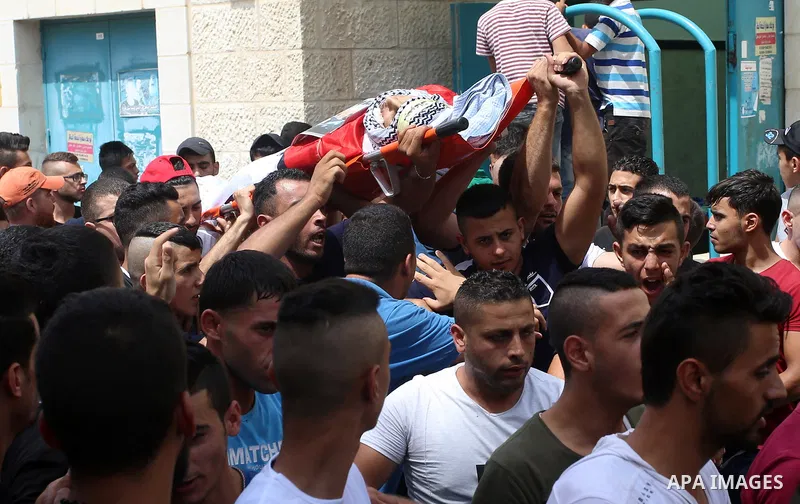 Palestinian mourners carry the body of 21-year-old Saad Salah during a funeral for Saad and 17-year-old Aws Salame, who were shot dead during clashes with the Israeli security forces in the West Bank city of Jenin, on Ju...