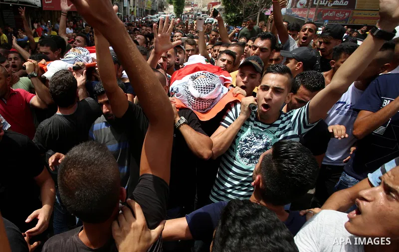 Palestinian mourners carry the bodies of 21-year-old Saad Salah during a funeral for Saad and 17-year-old Aws Salame, who were shot dead during clashes with the Israeli security forces in the West Bank city of Jenin, on...