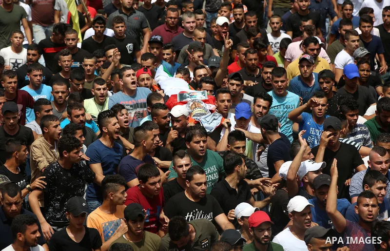 Palestinian mourners carry the body of 21-year-old Saad Salah during a funeral for Saad and 17-year-old Aws Salame, who were shot dead during clashes with the Israeli security forces in the West Bank city of Jenin, on Ju...