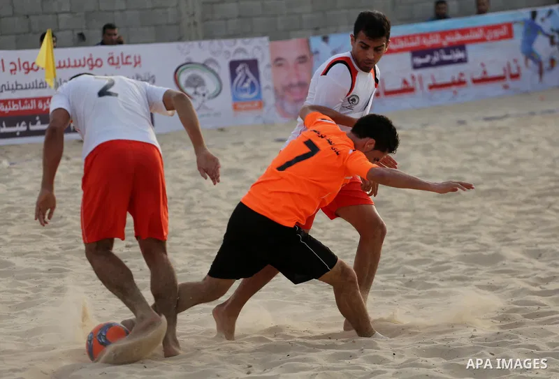 Palestinian Shabab Khan Younis players and al-Jalaa players compete for ball during the beach soccer (football) final match, in Gaza city on July 12, 2017. Photo by Mohammed Asad