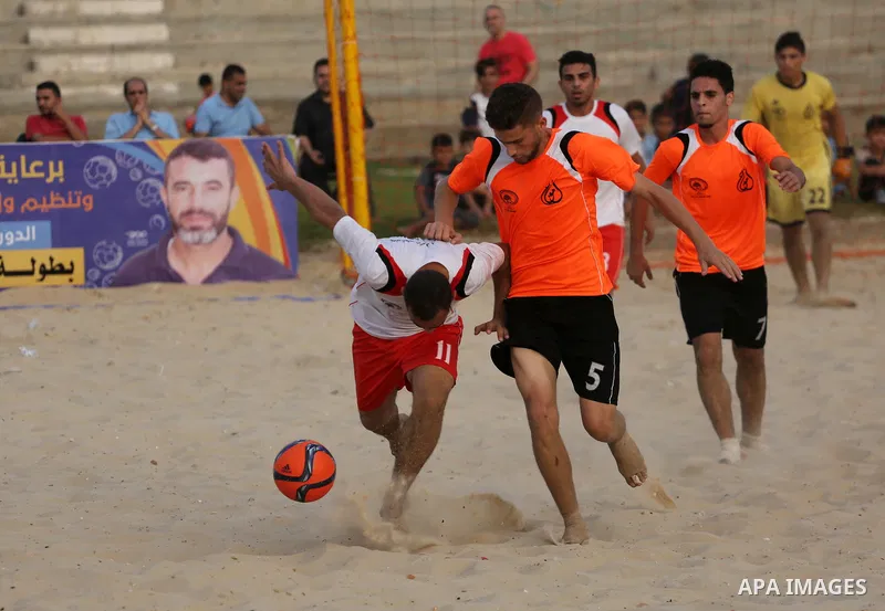 Palestinian Shabab Khan Younis players and al-Jalaa players compete for ball during the beach soccer (football) final match, in Gaza city on July 12, 2017. Photo by Mohammed Asad
