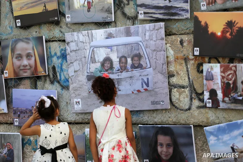 Palestinians take part in a photo exhibition called " A Thousand Pictures From Besieged City" at Gaza seaport in Gaza City on July 13, 2017. Photo by Mohammed Asad