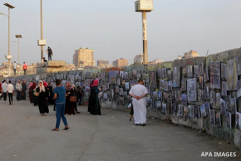 Palestinians take part in a photo exhibition called " A Thousand Pictures From Besieged City" at Gaza seaport in Gaza City on July 13, 2017. Photo by Mohammed Asad