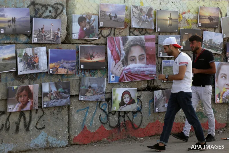 Palestinians take part in a photo exhibition called " A Thousand Pictures From Besieged City" at Gaza seaport in Gaza City on July 13, 2017. Photo by Mohammed Asad