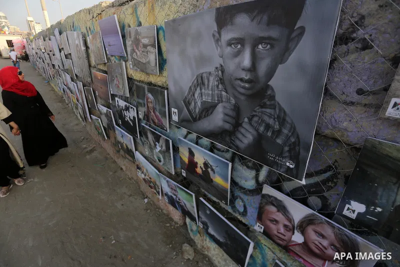 Palestinians take part in a photo exhibition called " A Thousand Pictures From Besieged City" at Gaza seaport in Gaza City on July 13, 2017. Photo by Mohammed Asad