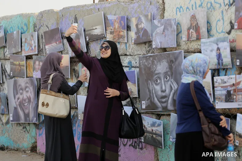 Palestinians take part in a photo exhibition called " A Thousand Pictures From Besieged City" at Gaza seaport in Gaza City on July 13, 2017. Photo by Mohammed Asad