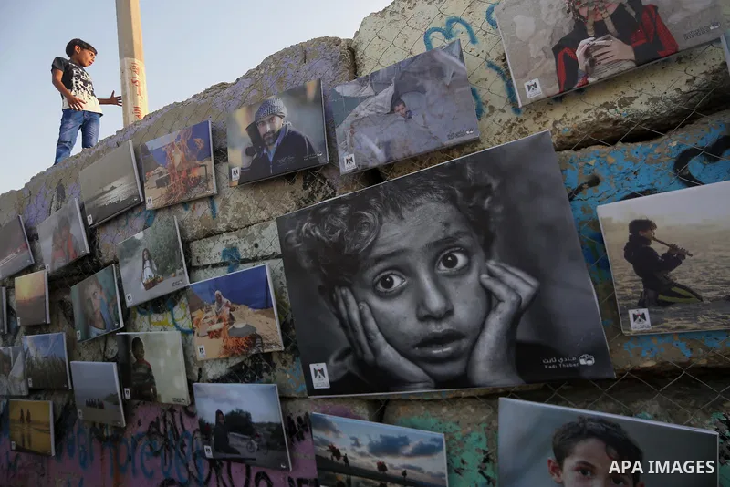 Palestinians take part in a photo exhibition called " A Thousand Pictures From Besieged City" at Gaza seaport in Gaza City on July 13, 2017. Photo by Mohammed Asad