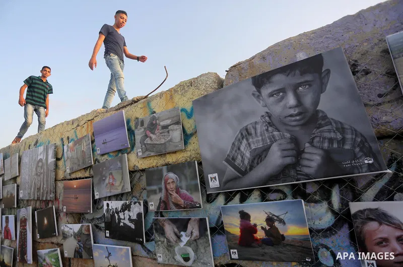 Palestinians take part in a photo exhibition called " A Thousand Pictures From Besieged City" at Gaza seaport in Gaza City on July 13, 2017. Photo by Mohammed Asad