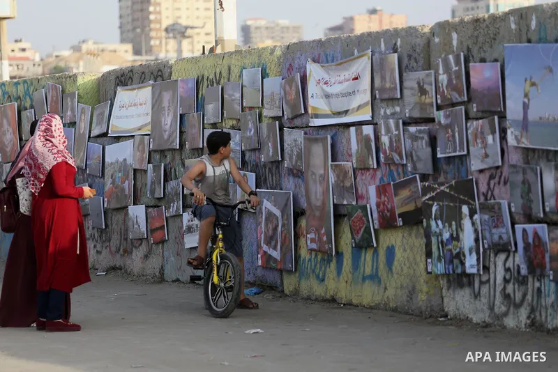 Palestinians take part in a photo exhibition called " A Thousand Pictures From Besieged City" at Gaza seaport in Gaza City on July 13, 2017. Photo by Mohammed Asad