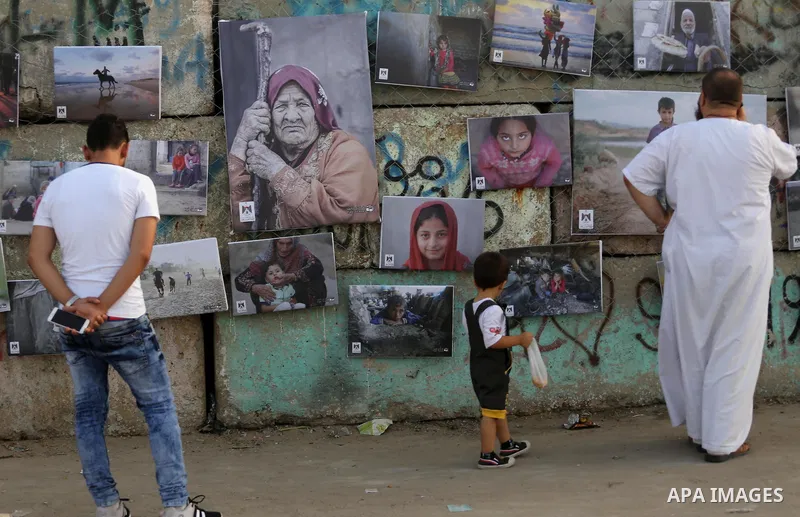 Palestinians take part in a photo exhibition called " A Thousand Pictures From Besieged City" at Gaza seaport in Gaza City on July 13, 2017. Photo by Mohammed Asad