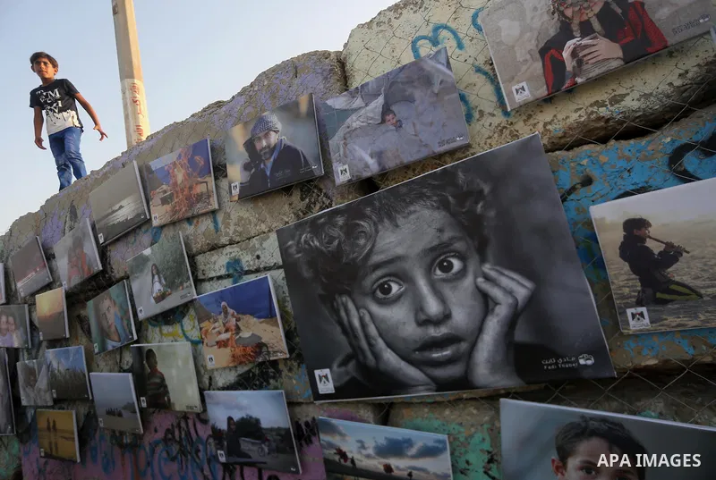 Palestinians take part in a photo exhibition called " A Thousand Pictures From Besieged City" at Gaza seaport in Gaza City on July 13, 2017. Photo by Mohammed Asad