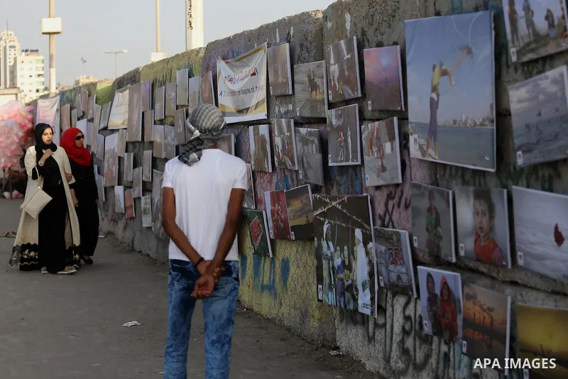 Palestinians take part in a photo exhibition called " A Thousand Pictures From Besieged City" at Gaza seaport in Gaza City on July 13, 2017. Photo by Mohammed Asad