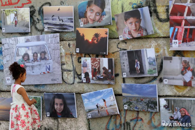 Palestinians take part in a photo exhibition called " A Thousand Pictures From Besieged City" at Gaza seaport in Gaza City on July 13, 2017. Photo by Mohammed Asad