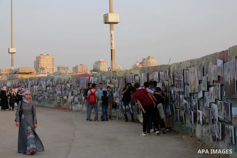 Palestinians take part in a photo exhibition called " A Thousand Pictures From Besieged City" at Gaza seaport in Gaza City on July 13, 2017. Photo by Mohammed Asad