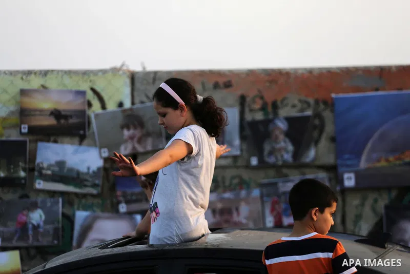 Palestinians take part in a photo exhibition called " A Thousand Pictures From Besieged City" at Gaza seaport in Gaza City on July 13, 2017. Photo by Mohammed Asad
