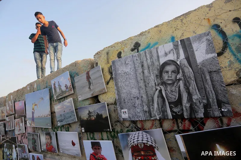 Palestinians take part in a photo exhibition called " A Thousand Pictures From Besieged City" at Gaza seaport in Gaza City on July 13, 2017. Photo by Mohammed Asad