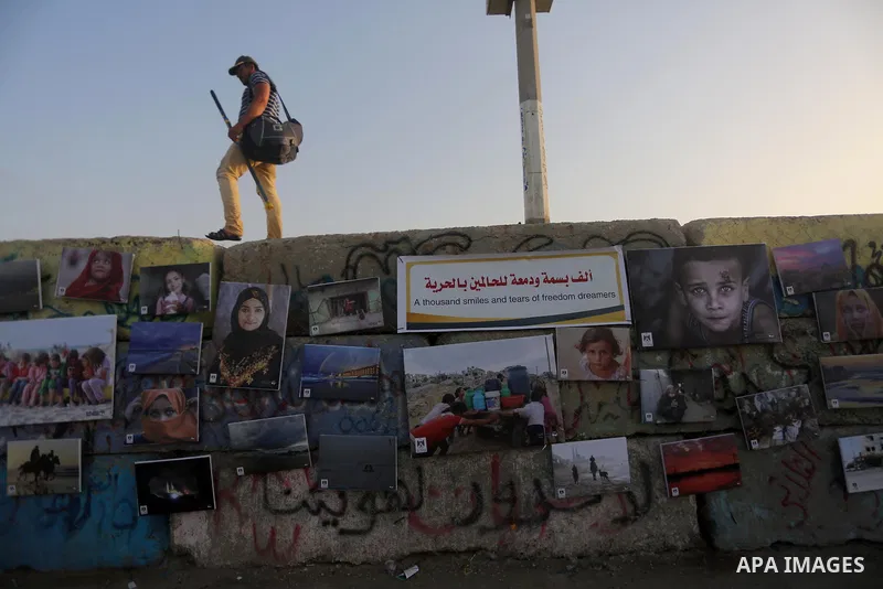 Palestinians take part in a photo exhibition called " A Thousand Pictures From Besieged City" at Gaza seaport in Gaza City on July 13, 2017. Photo by Mohammed Asad