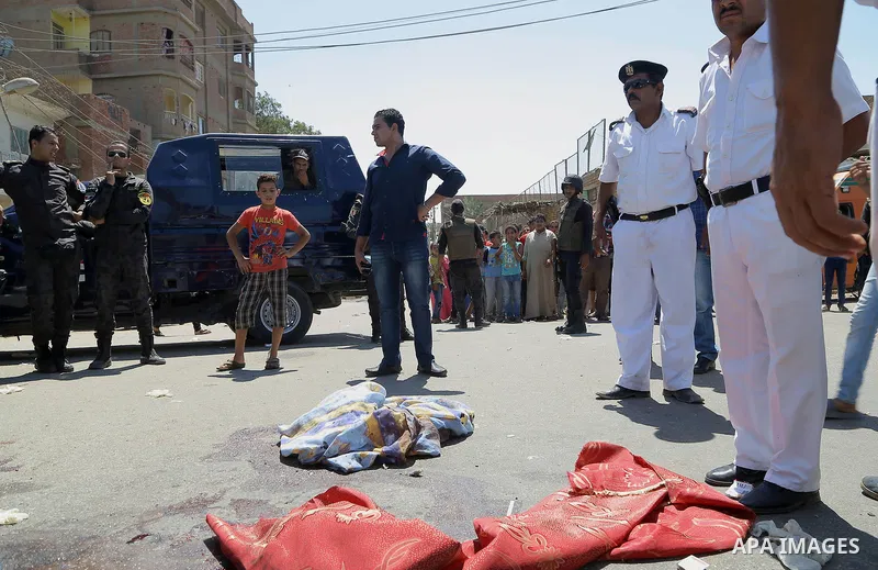 Egyptian policemen inspect the scene of an attack which left five of their colleagues killed in a shooting near Badrasheen, a town some 20 kilometres (12 miles) from Cairo where militants have also targeted security forc...