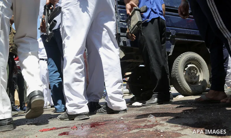 Egyptian policemen inspect the scene of an attack which left five of their colleagues killed in a shooting near Badrasheen, a town some 20 kilometres (12 miles) from Cairo where militants have also targeted security forc...