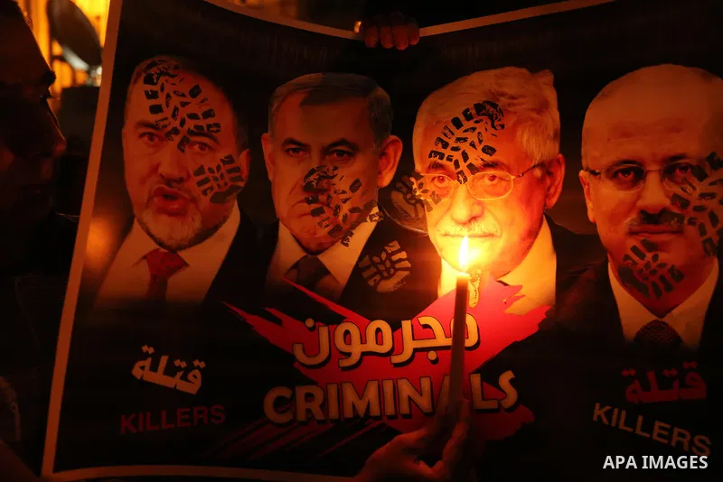 Palestinian boys hold candles and posters during a protest against the blockade on Gaza, in Khan Younis in the southern Gaza Strip July 14, 2017. The poster (back) reads, "Abbas (Palestinian president) does not represent...