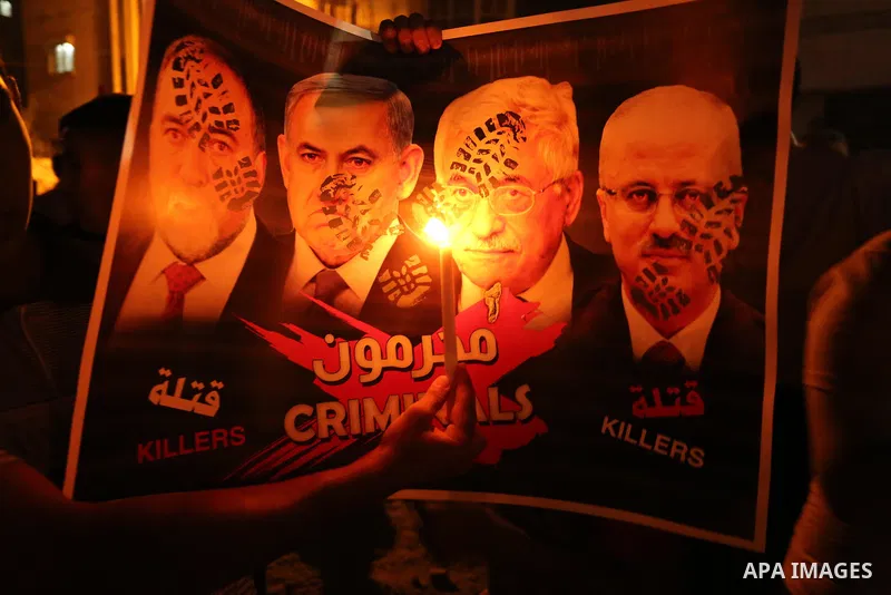 Palestinian boys hold candles and posters during a protest against the blockade on Gaza, in Khan Younis in the southern Gaza Strip July 14, 2017. The poster (back) reads, "Abbas (Palestinian president) does not represent...